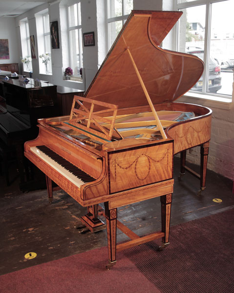 Restored, 1910, Bechstein Model B grand piano with a book-matched, satinwood case with boxwood stringing inlay. Entire cabinet inlaid with swagged bellflowers and bows. Piano has gate legs attached with a cross stretcher.  Piano has an eighty-eight note keyboard and a two-pedal lyre