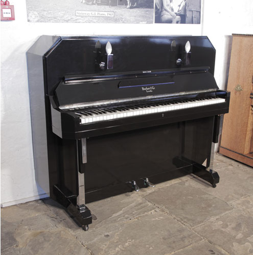 A Barker upright piano with an Art Deco style, black case. Cabinet features strong angular styling and chrome fittings