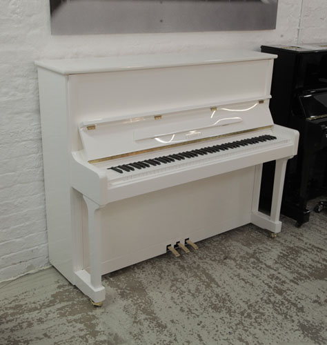 Brand New Feurich Model 122 Universal upright piano with a white case and chrome fittings.  Piano has an eighty-eight note keyboard and three pedals.