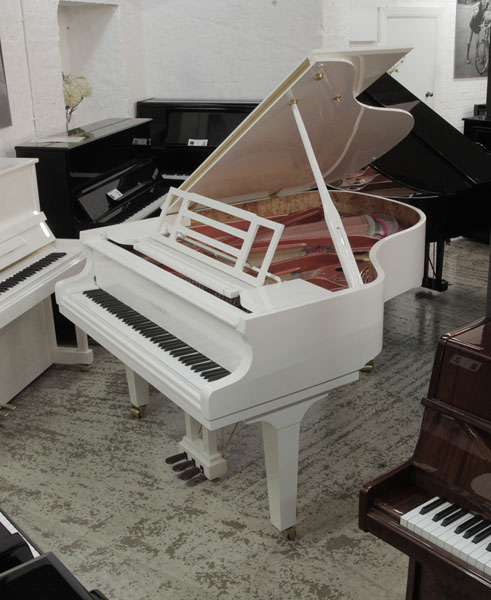 Brand new, Feurich F179 Dynamic grand piano in white gloss with brass fittings. Piano has an eighty-eight note keyboard and a three-pedal piano lyre.