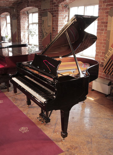 A 1996, Steinway Model M grand piano with a with a black case and brass fittings. Piano has an eighty-eight note keyboard and a three-pedal lyre. 
