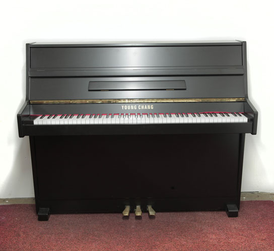 Piano for sale. Pre-owned, 1988, Young Chang U-109 upright piano with a black, satin case and brass fittings. Piano has an eighty-eight note keyboard and two pedals. 